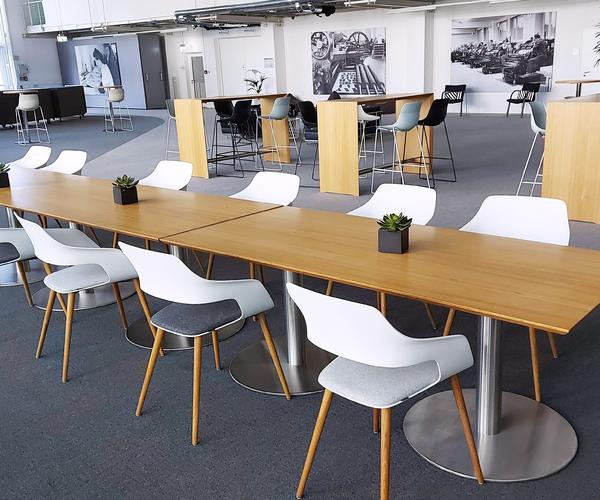 Großer Raum mit Tischreihen und Stühlen